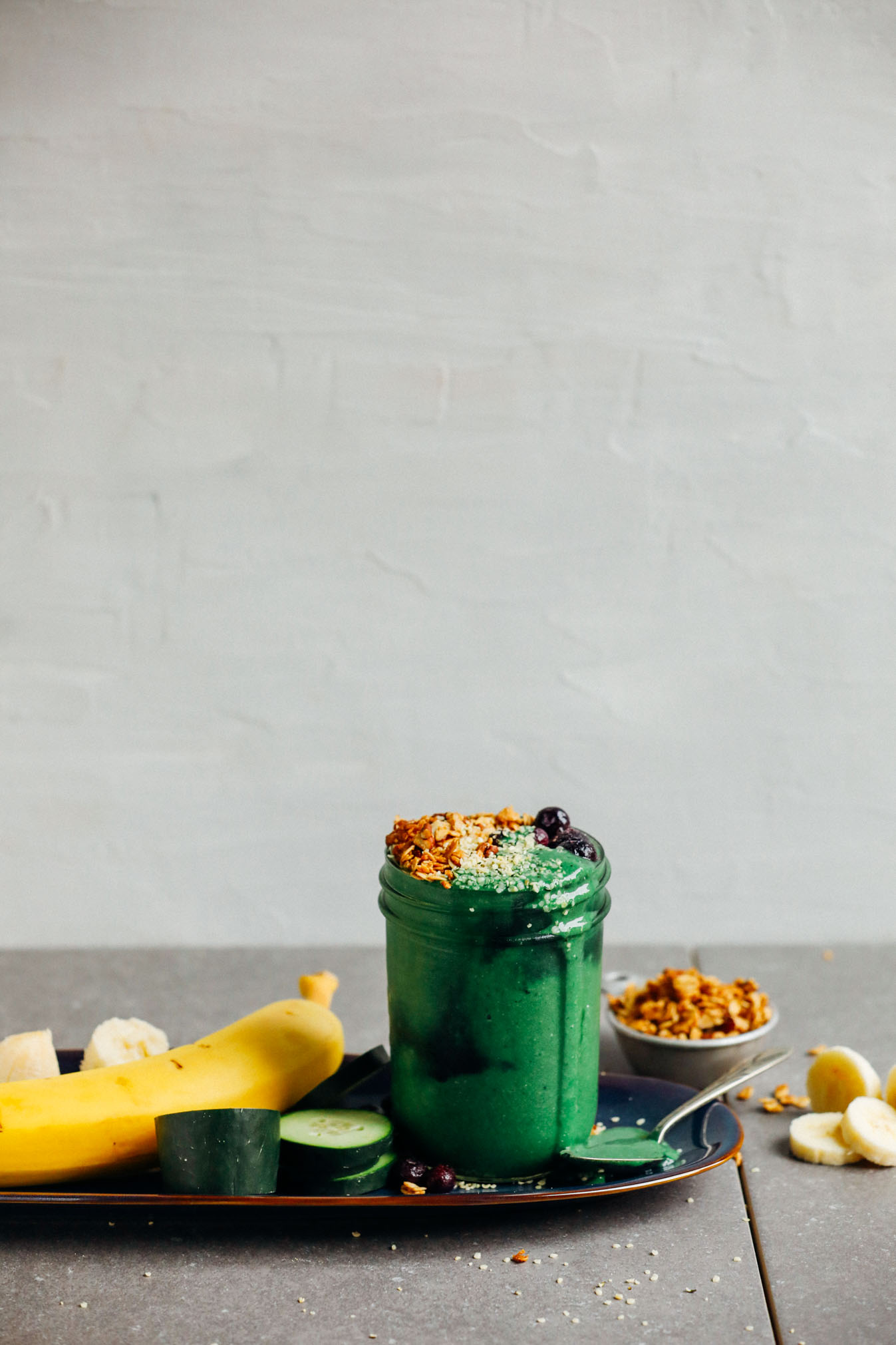 A spirulina smoothie topped with granola and blueberries